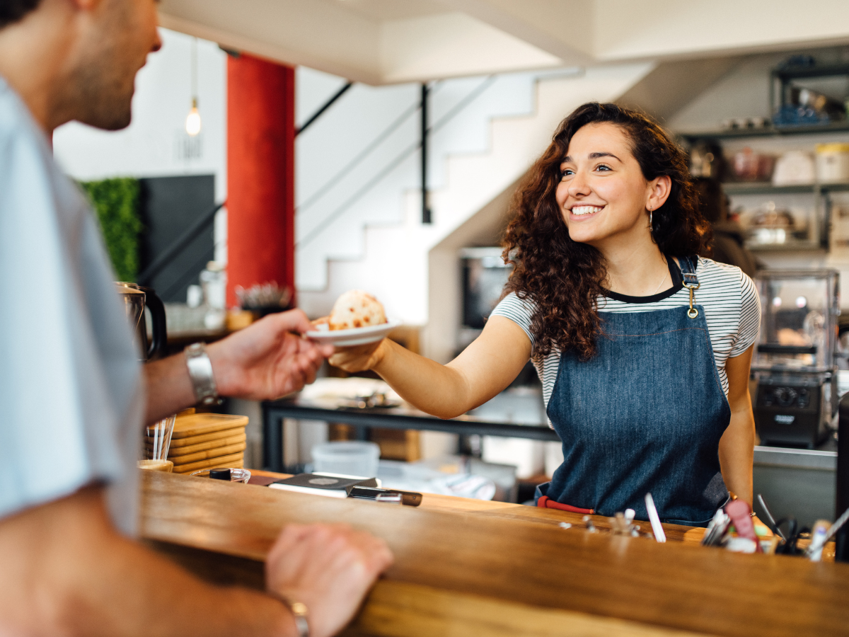 Flexible jobs for college students: barista handing a customer their order